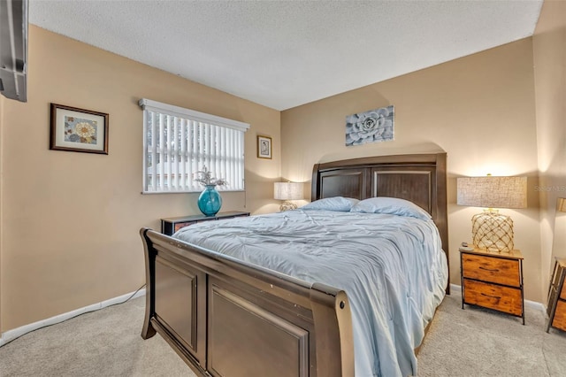 bedroom with light carpet and a textured ceiling