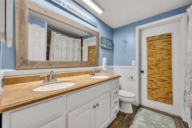 bathroom featuring hardwood / wood-style flooring, toilet, vanity, and wood walls