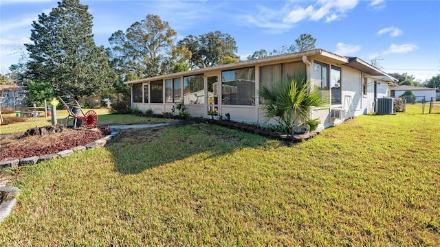 view of front facade featuring a front lawn, cooling unit, and a sunroom