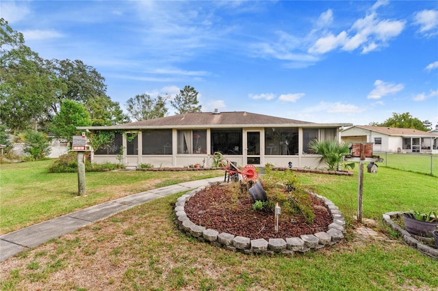 view of front facade with a front lawn and a sunroom