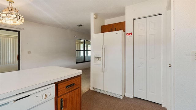 kitchen featuring decorative light fixtures, dark carpet, and white appliances