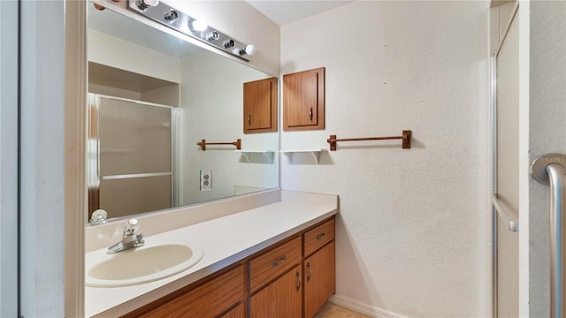 bathroom with a shower with door and vanity