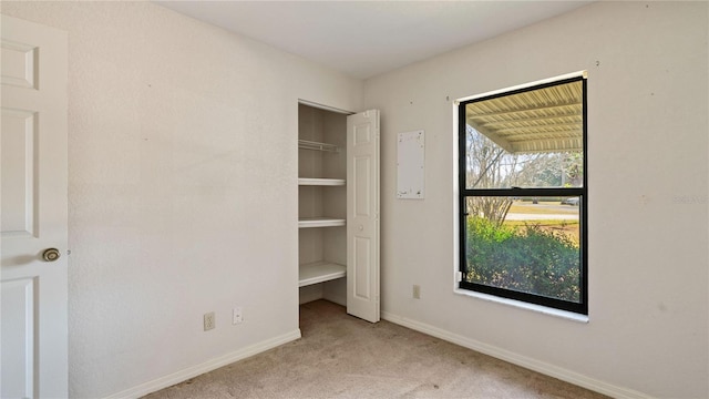 unfurnished bedroom featuring light colored carpet and multiple windows