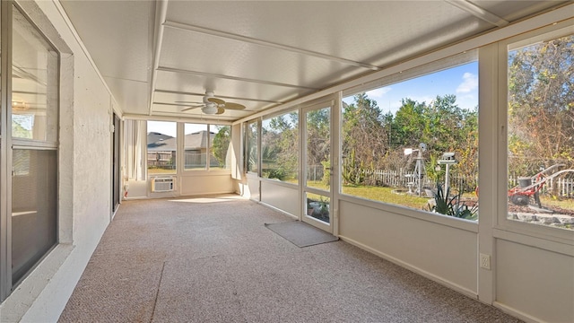 unfurnished sunroom featuring ceiling fan and a wall mounted AC