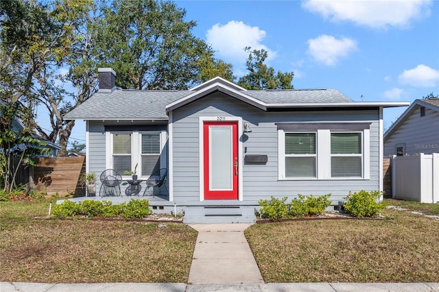 bungalow-style house with a front yard and a patio area