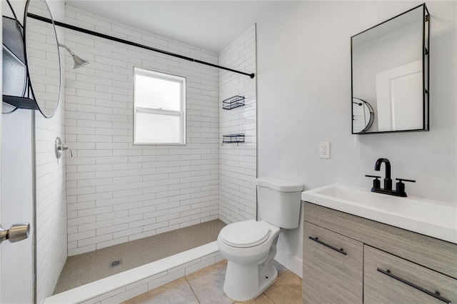 bathroom with vanity, a tile shower, tile patterned floors, and toilet