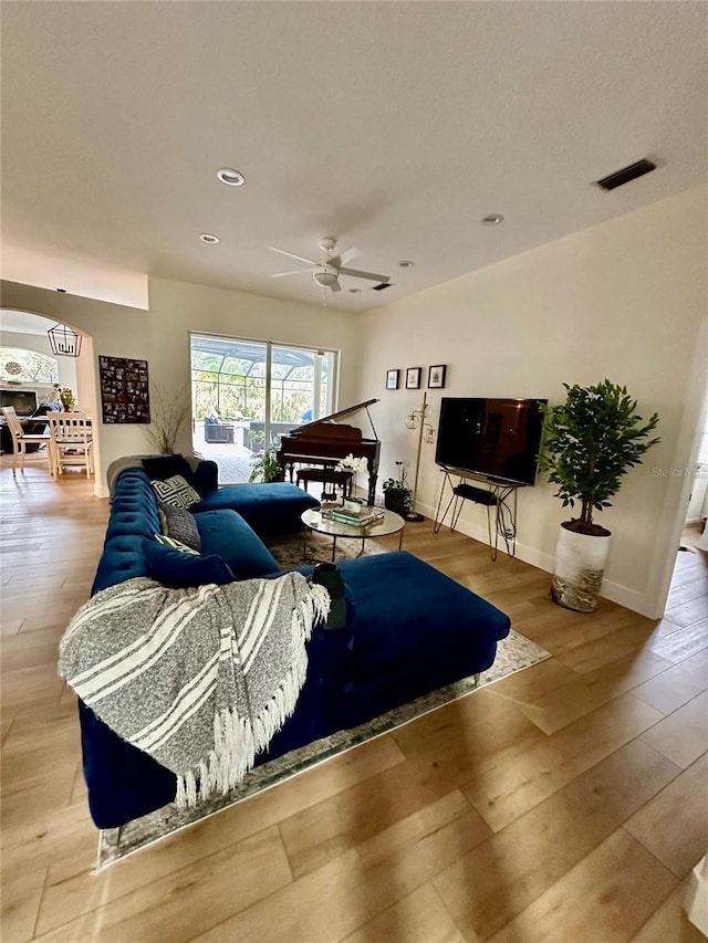 living room featuring ceiling fan and light hardwood / wood-style flooring