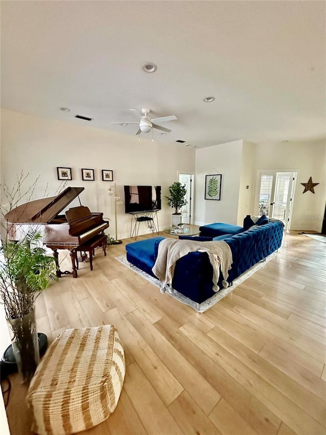 living room with ceiling fan and light hardwood / wood-style flooring