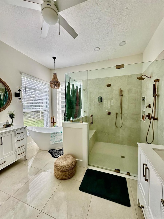 bathroom featuring ceiling fan, tile patterned floors, vanity, and shower with separate bathtub