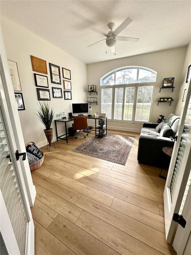 office space featuring a textured ceiling, ceiling fan, and light hardwood / wood-style floors