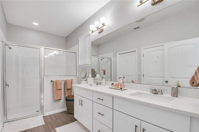 bathroom with a shower with shower door, vanity, and hardwood / wood-style floors