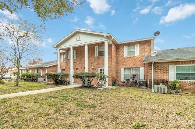 neoclassical home with a front lawn and cooling unit