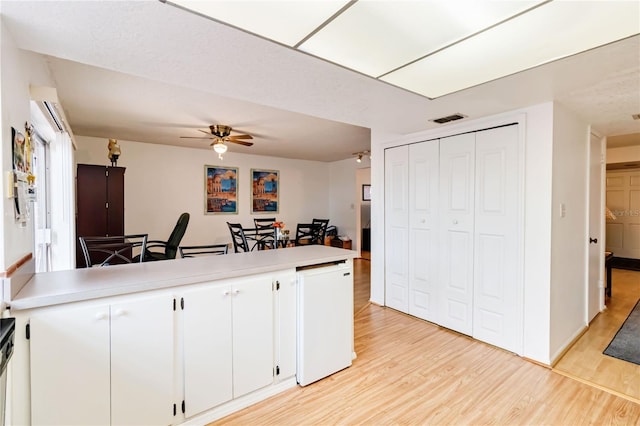 kitchen featuring ceiling fan, white cabinets, and light hardwood / wood-style flooring