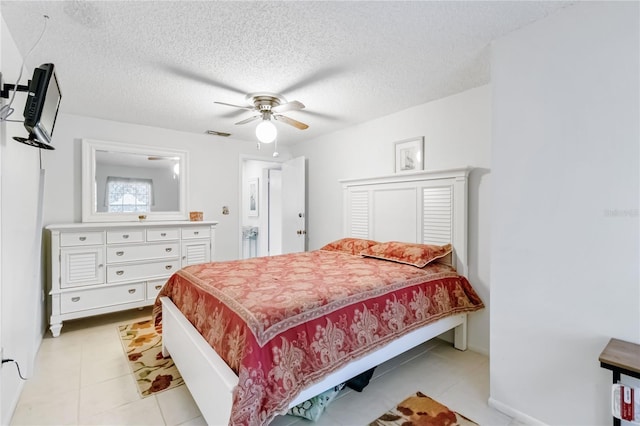 bedroom with ceiling fan, a textured ceiling, and light tile patterned floors