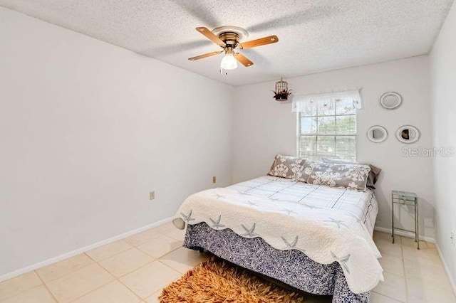 tiled bedroom featuring ceiling fan and a textured ceiling