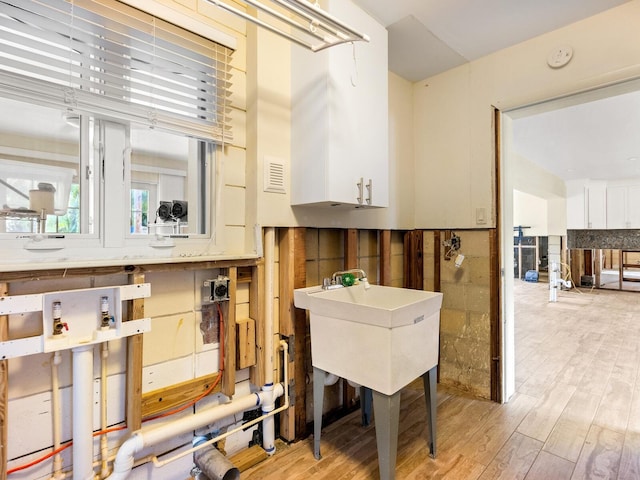 interior space with light hardwood / wood-style floors and white cabinets