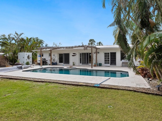 rear view of house featuring a lawn and a patio