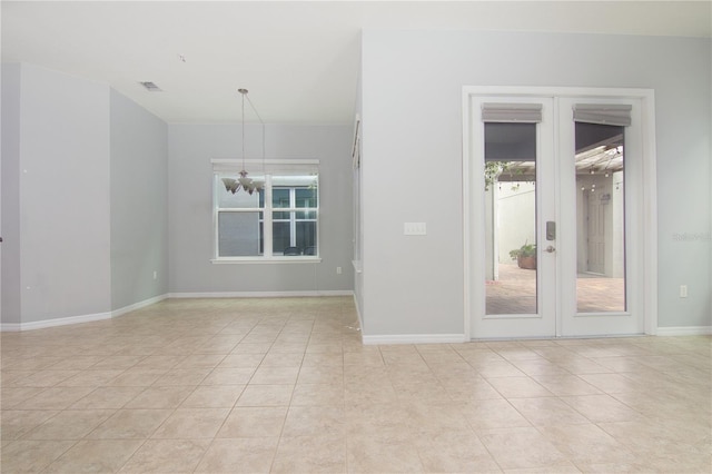 tiled spare room with an inviting chandelier