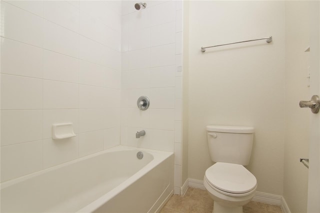 bathroom featuring toilet, tile patterned flooring, and tiled shower / bath