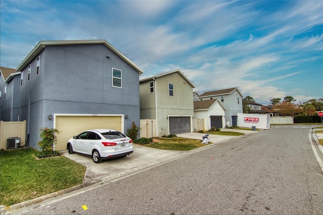 view of front of home with central AC unit and a garage