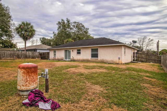 back of property featuring a lawn