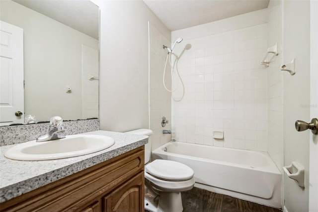 full bathroom featuring toilet, a textured ceiling, tiled shower / bath, wood-type flooring, and vanity