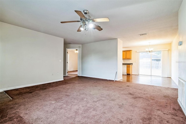 unfurnished living room with ceiling fan with notable chandelier and carpet floors