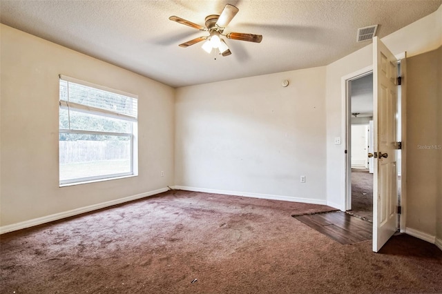 carpeted spare room with a textured ceiling and ceiling fan