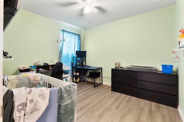 bedroom featuring ceiling fan, a textured ceiling, and light wood-type flooring