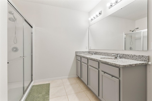 bathroom featuring vanity, a textured ceiling, an enclosed shower, and tile patterned flooring