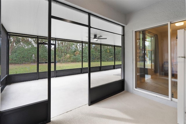 unfurnished sunroom with a healthy amount of sunlight and ceiling fan