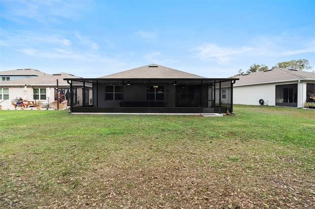 back of property featuring a sunroom and a lawn