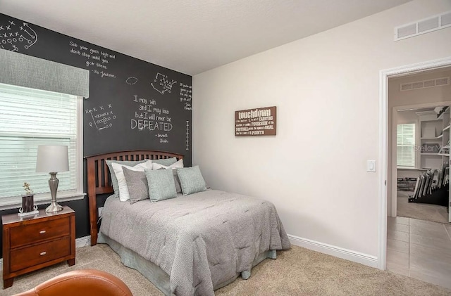 bedroom featuring light carpet and multiple windows