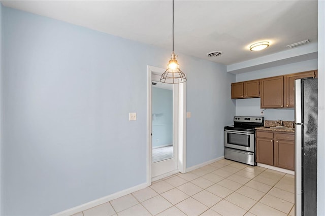 kitchen with pendant lighting, fridge, sink, stainless steel range with electric cooktop, and light tile patterned floors