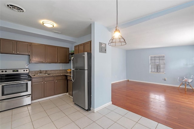 kitchen with light tile patterned floors, appliances with stainless steel finishes, pendant lighting, and sink