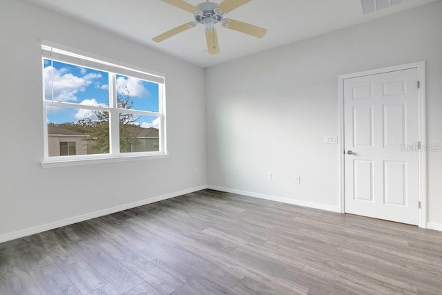 empty room with ceiling fan and light hardwood / wood-style flooring