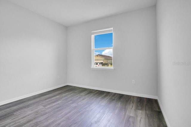 empty room with dark hardwood / wood-style flooring