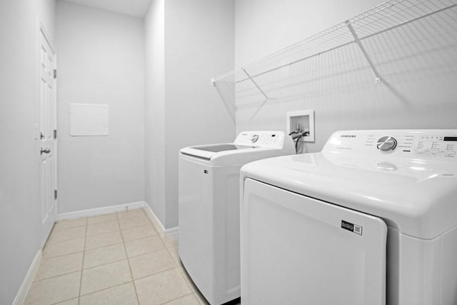 washroom with washing machine and dryer and light tile patterned flooring