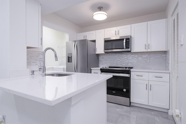 kitchen featuring kitchen peninsula, stainless steel appliances, white cabinetry, and sink