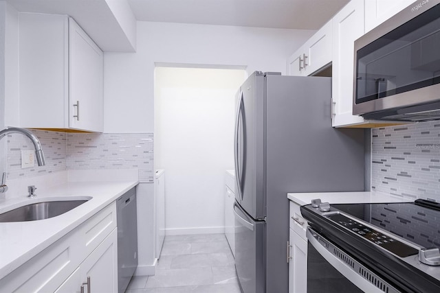 kitchen featuring backsplash, appliances with stainless steel finishes, sink, and white cabinetry