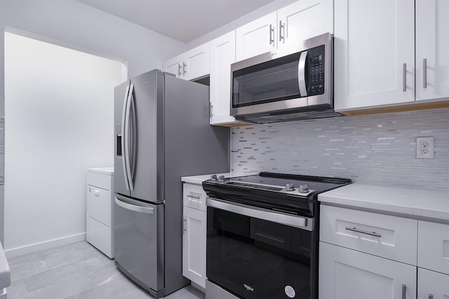 kitchen featuring light stone countertops, white cabinets, washer / clothes dryer, stainless steel appliances, and decorative backsplash