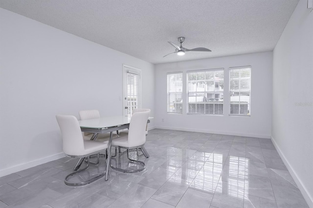 tiled dining room with a textured ceiling and ceiling fan