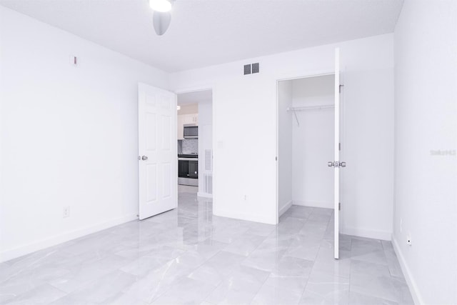 unfurnished bedroom with ceiling fan, a textured ceiling, and a closet