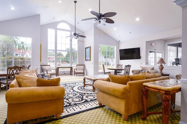 living room with ceiling fan, plenty of natural light, and high vaulted ceiling