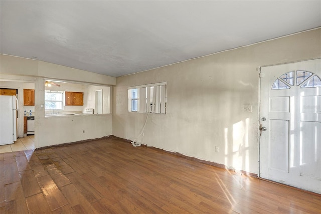 foyer entrance with ceiling fan and light hardwood / wood-style floors