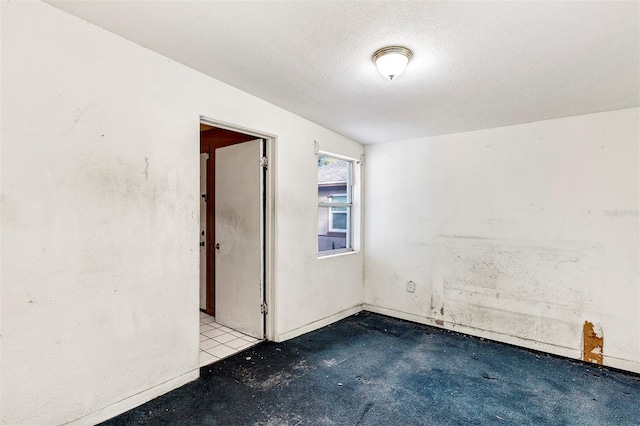 unfurnished room with a textured ceiling