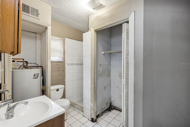 bathroom featuring water heater, toilet, tile patterned floors, a textured ceiling, and vanity