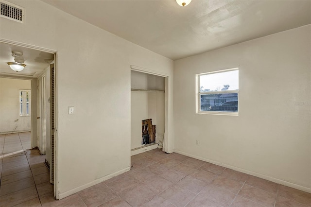 unfurnished bedroom featuring a closet and light tile patterned floors