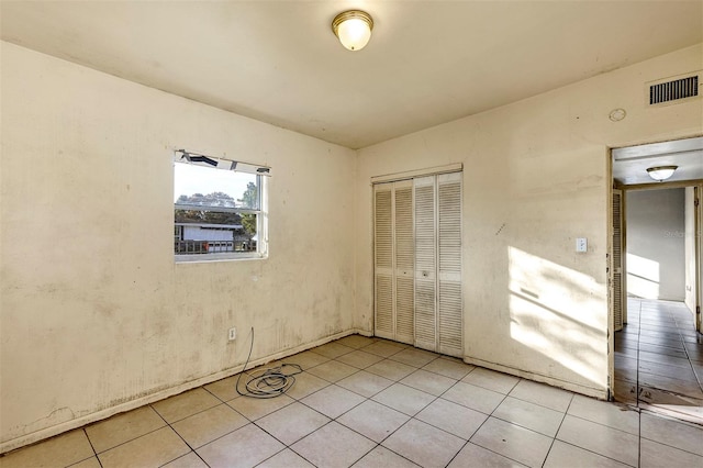 unfurnished bedroom with a closet and light tile patterned flooring