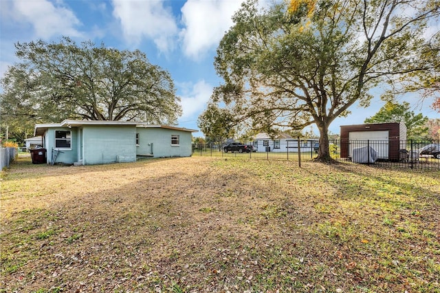 view of yard featuring a garage and an outbuilding